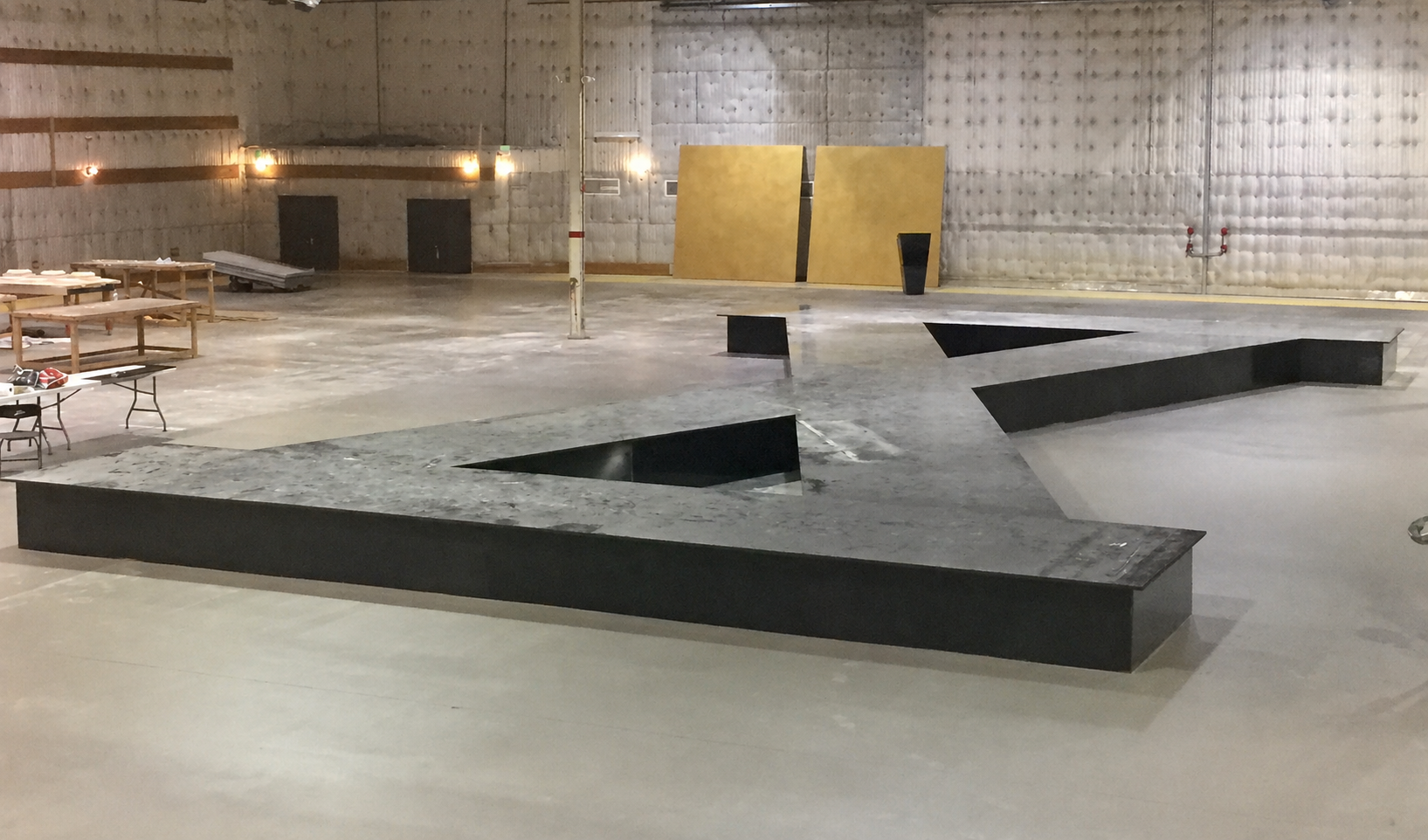 Customized Stages and Fabrication — Custom angular black stage pre-install — fabricated geometric platform ready for delivery