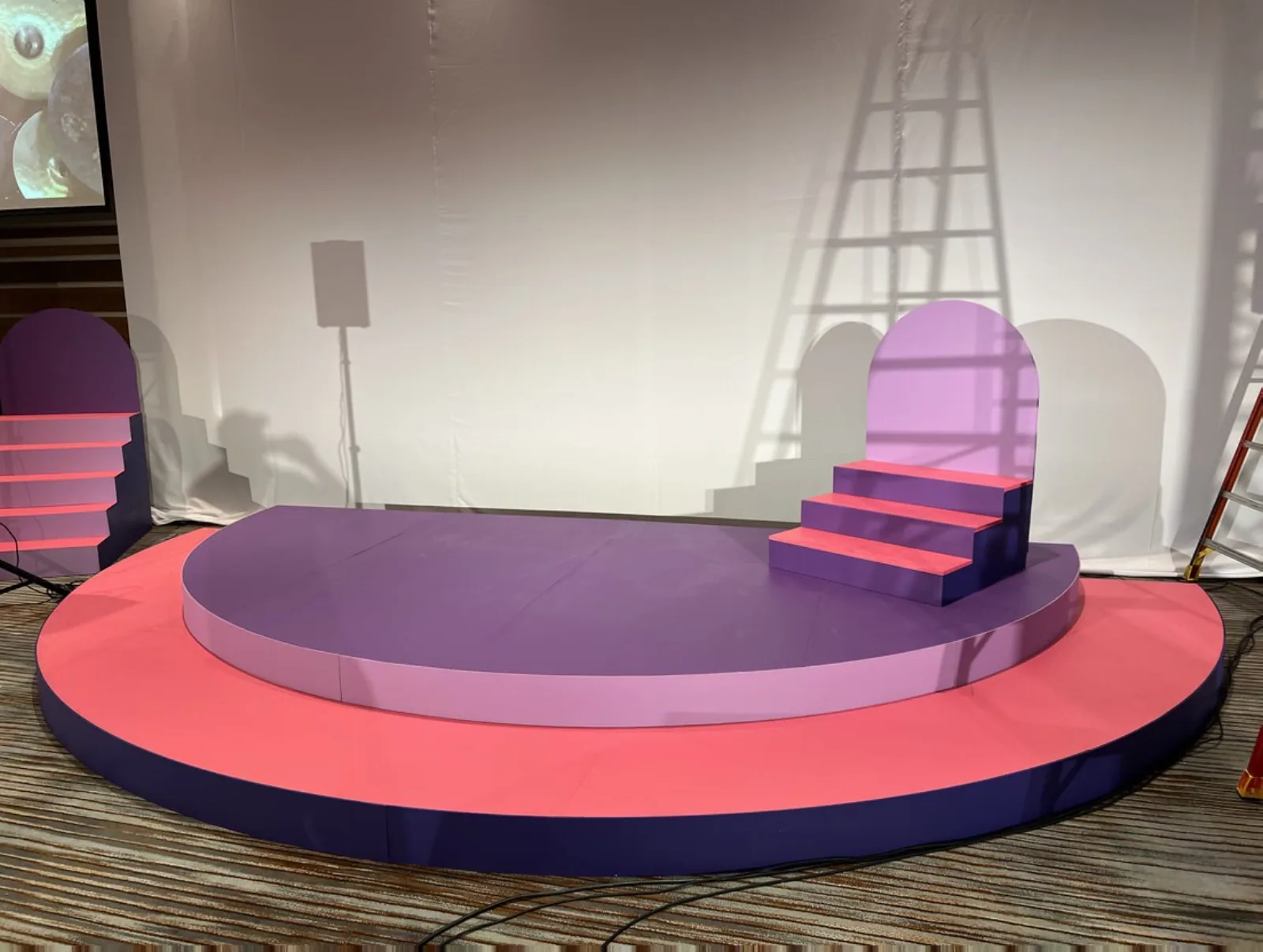 Customized Stages and Fabrication — Custom purple half-circle stage with arched stair detail — corporate event