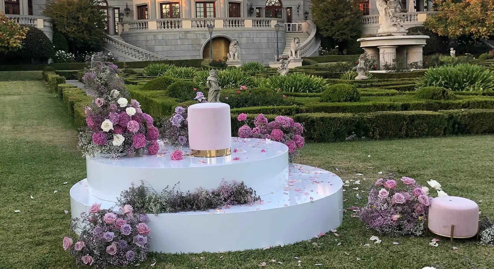 Circular and Round Stage Rental — Stacked round white wedding stage with floral installation — estate garden ceremony and sweetheart reveal