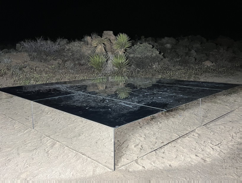 Stage and Runaway Rental — Black mirrored steel-deck platform in the desert — clean reflective finish for a nighttime build