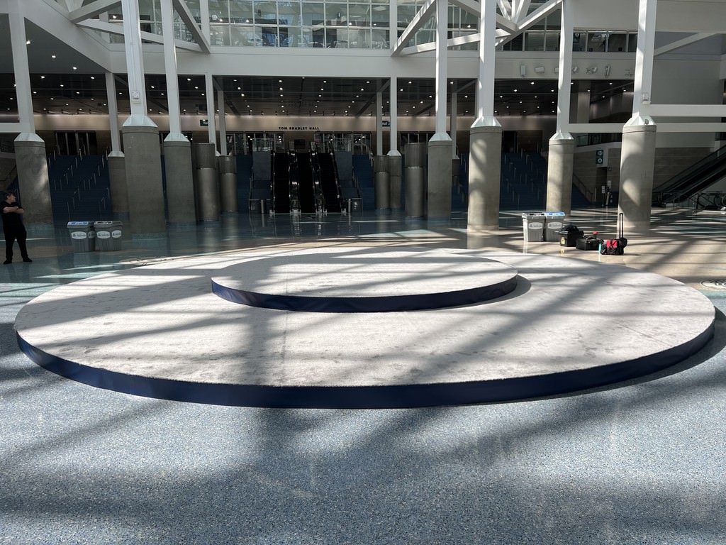 Circular and Round Stage Rental — 32-foot two-tier circular stage in a convention hall — center-floor presentation build