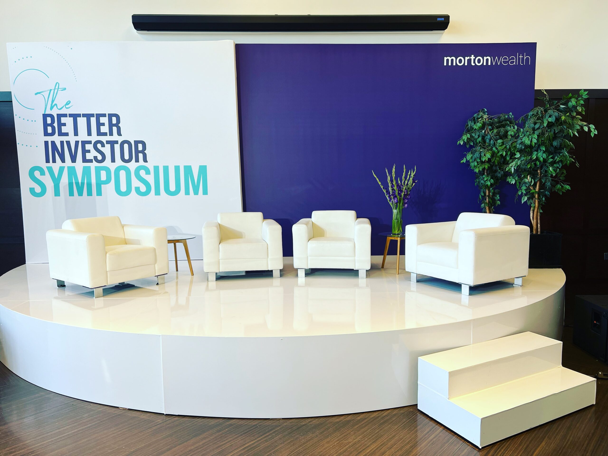 Corporate event stage rental with white lounge furniture setup by RCC Events in Los Angeles